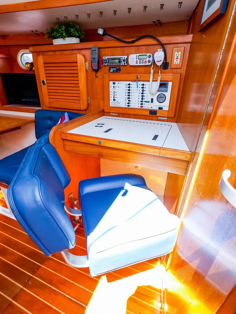 Slide: The Image of Navigation station inside a 2001 Catalina 36 MkII sailboat with blue seating and control panel. - 25