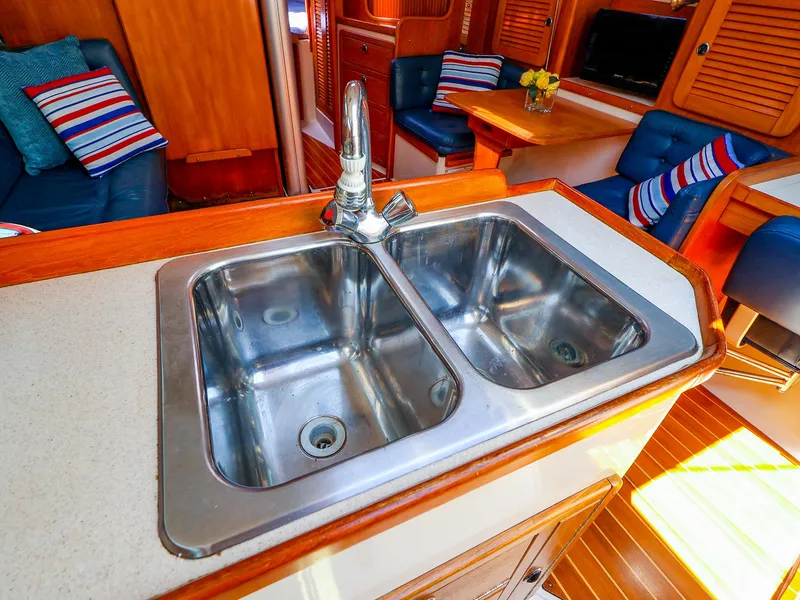 Slide: The Image of Galley sink in 2001 Catalina 36 MkII yacht interior, featuring cozy seating and wooden accents. - 31
