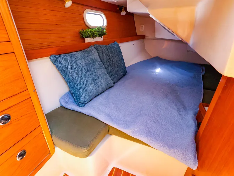 Slide: The Image of Cozy cabin interior of 2001 Catalina 36 MkII sailboat with blue bedding and wooden accents. - 43