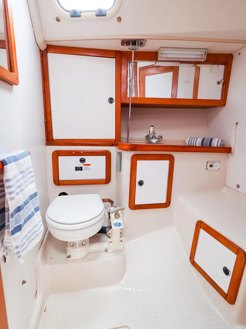 Slide: The Image of 2001 Catalina 36 MkII yacht bathroom with wooden trim, toilet, sink, and storage cabinets. - 45