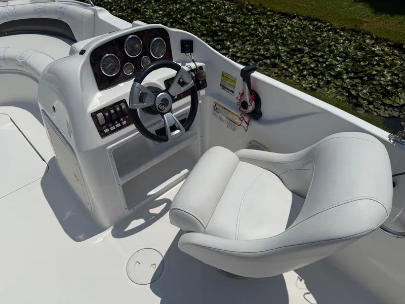 Slide: The Image of 2013 Hurricane SunDeck Sport 188 OB boat cockpit with steering wheel and white captain's chair. - 10