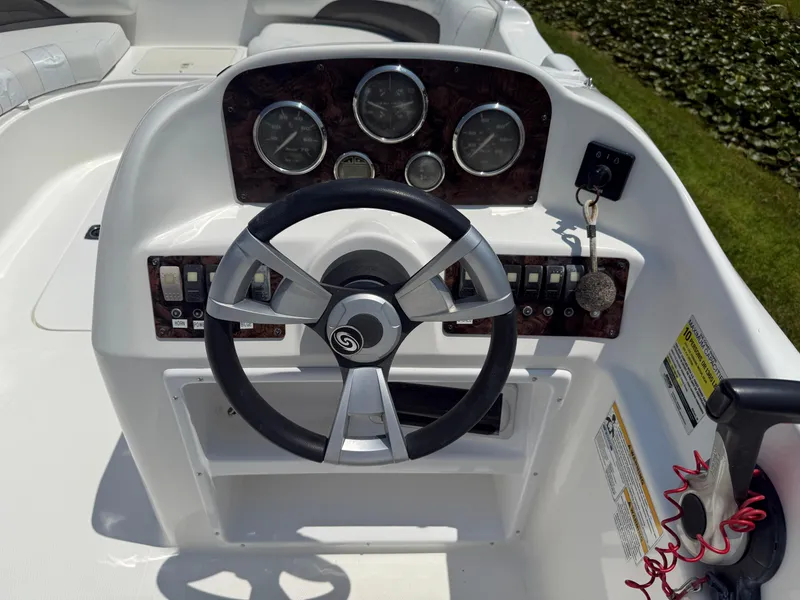 Slide: The Image of 2013 Hurricane SunDeck Sport 188 OB boat dashboard with steering wheel and control panel. - 11