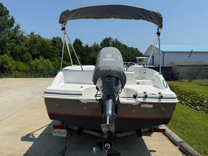 Slide: The Image of 2013 Hurricane SunDeck Sport 188 OB boat with Yamaha outboard motor, parked outdoors. - 2
