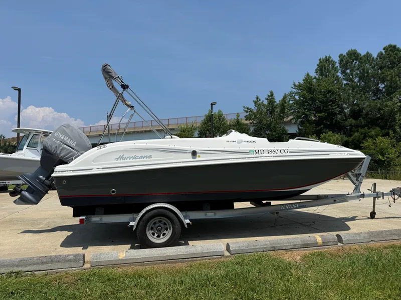 Slide: The Image of 2013 Hurricane SunDeck Sport 188 OB boat on trailer, parked outdoors. - 4