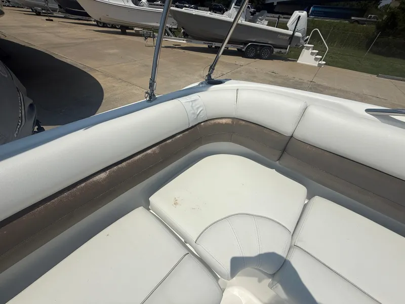Slide: The Image of 2013 Hurricane SunDeck Sport 188 OB boat interior with white seating and visible docked boats. - 7
