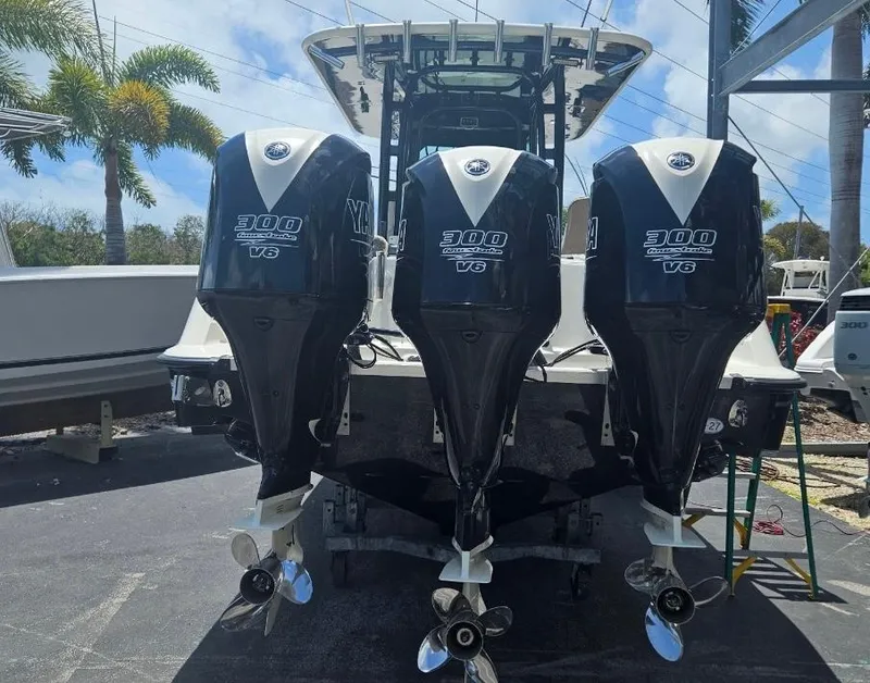 Slide: The Image of 2015 Hydra-Sports 3400 CC boat docked near a marina with lush greenery. - 3