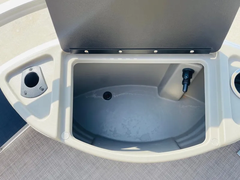 Slide: The Image of 2025 Sun Tracker Bass Buggy 18 DLX storage compartment with cup holder and drain plug. - 14