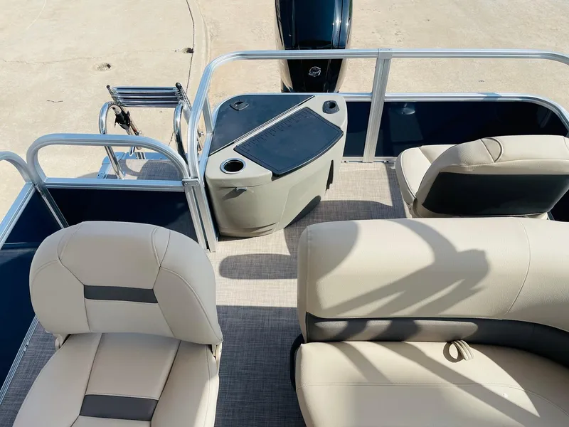 Slide: The Image of 2025 Sun Tracker Bass Buggy 18 DLX interior with beige seating and helm station. - 25