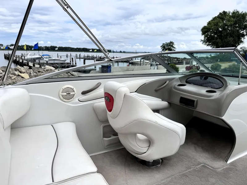 Slide: The Image of 2004 Crownline 206 LS boat interior with white seating, dockside view. - 11