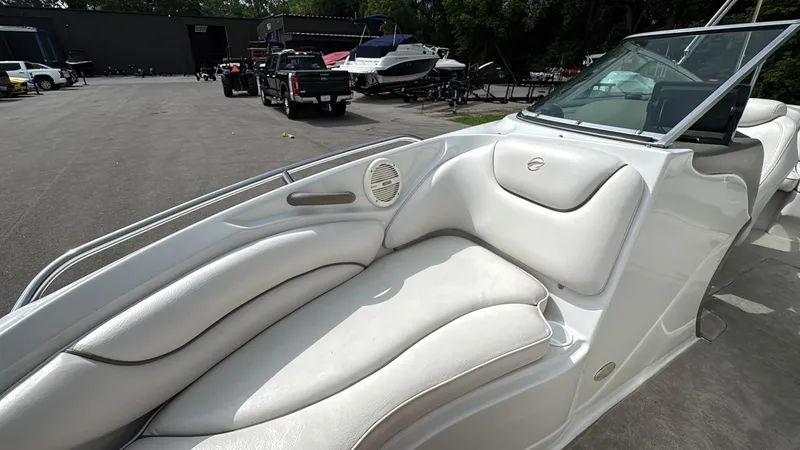Slide: The Image of 2004 Crownline 206 LS boat interior with white leather seating, parked outdoors. - 20
