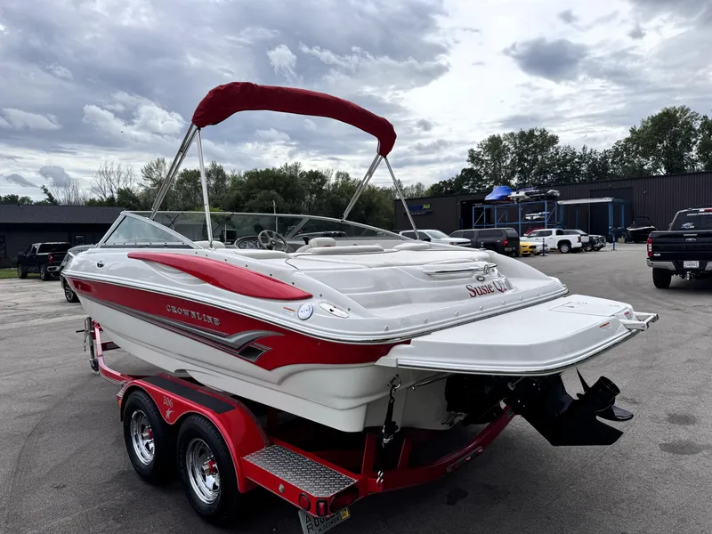 Slide: The Image of 2004 Crownline 206 LS boat with red accents on a trailer, parked outdoors. - 4