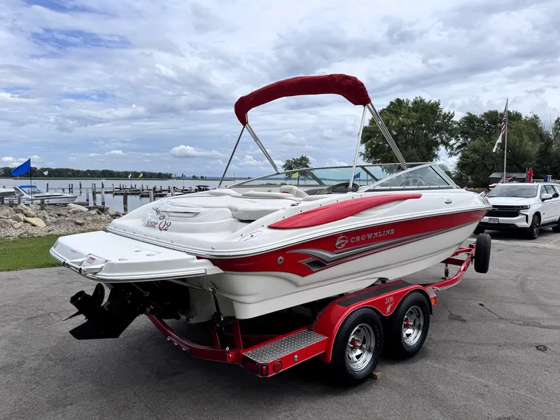 Slide: The Image of 2004 Crownline 206 LS boat on trailer by lakeside, featuring red and white design. - 5