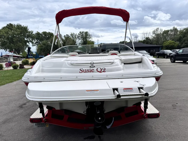 Slide: The Image of 2004 Crownline 206 LS boat with red canopy, parked on pavement. - 6