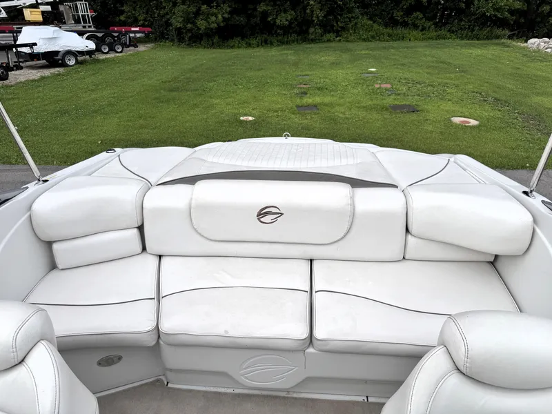 Slide: The Image of 2004 Crownline 206 LS boat interior with white cushioned seating and green grass background. - 9