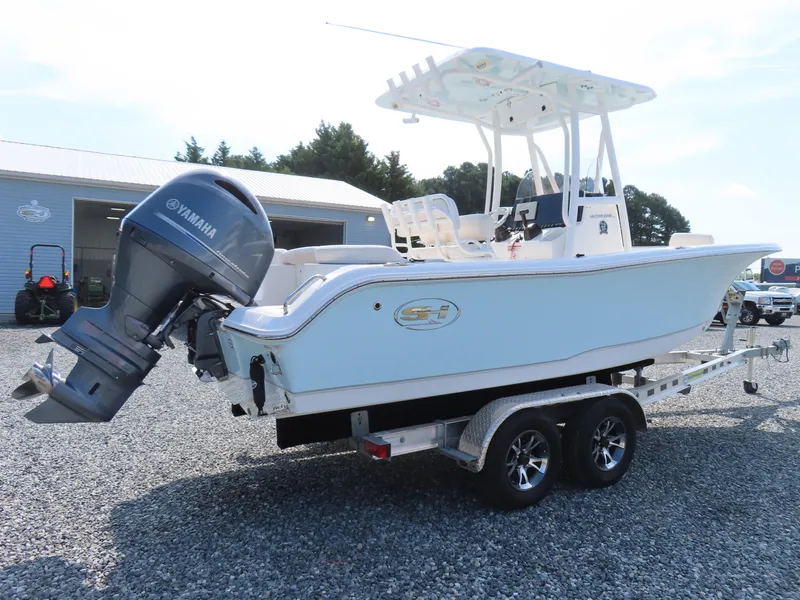 Slide: The Image of 2021 Sea Hunt Ultra 219 boat with Yamaha engine on trailer, parked outdoors. - 2