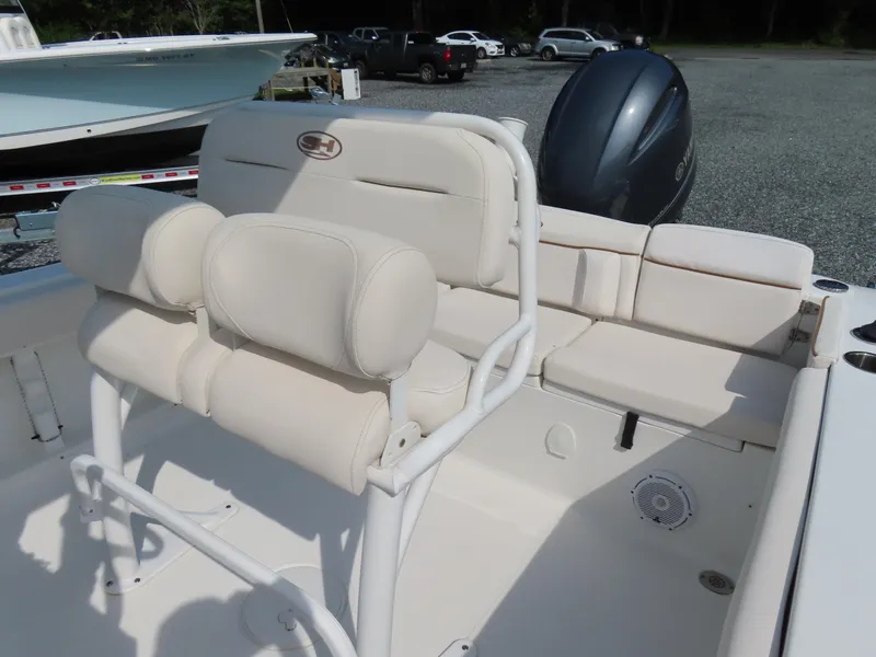 Slide: The Image of 2021 Sea Hunt Ultra 219 boat interior with cushioned seating and Yamaha outboard motor. - 21
