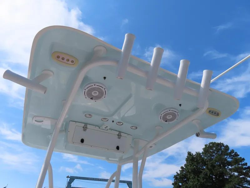 Slide: The Image of 2021 Sea Hunt Ultra 219 boat top view with rod holders and speakers against blue sky. - 29