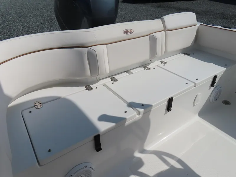 Slide: The Image of 2021 Sea Hunt Ultra 219 boat interior with white cushioned seating and storage compartments. - 31