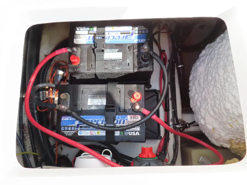 Slide: The Image of Battery compartment of a 2021 Sea Hunt Ultra 219 boat, featuring dual batteries and wiring. - 33