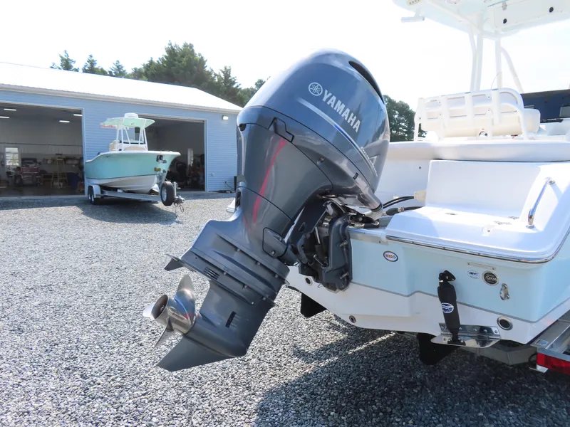 Slide: The Image of 2021 Sea Hunt Ultra 219 boat with Yamaha outboard motor in a gravel lot. - 4