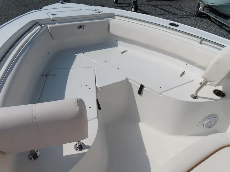 Slide: The Image of 2021 Sea Hunt Ultra 219 boat interior with white seating and storage compartments. - 8