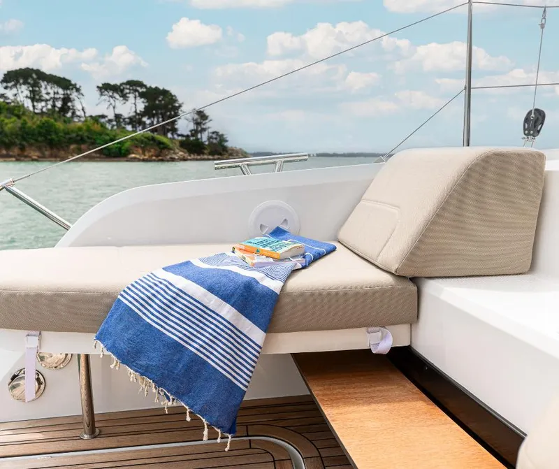 Slide: The Image of Luxurious Fountaine Pajot NEW 41 yacht deck with cushioned seating, towel, and book, 2025 model. - 15