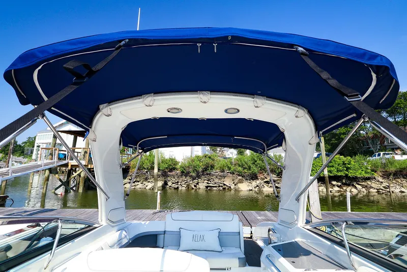 Slide: The Image of 2013 Formula 290 Bowrider with blue canopy, docked by a scenic riverside. - 10