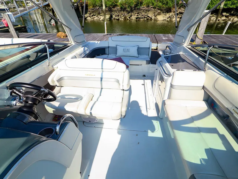 Slide: The Image of 2013 Formula 290 Bowrider interior with white seating and steering wheel, docked by the water. - 16