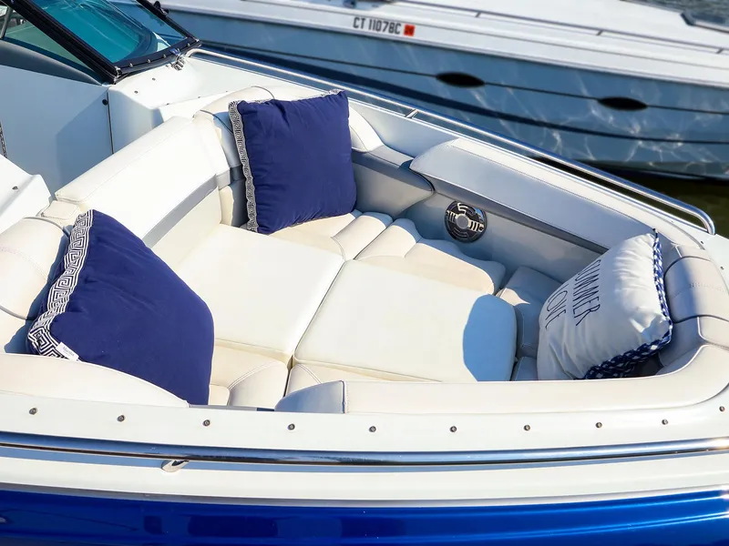 Slide: The Image of 2013 Formula 290 Bowrider with plush seating and blue cushions, docked beside another boat. - 18