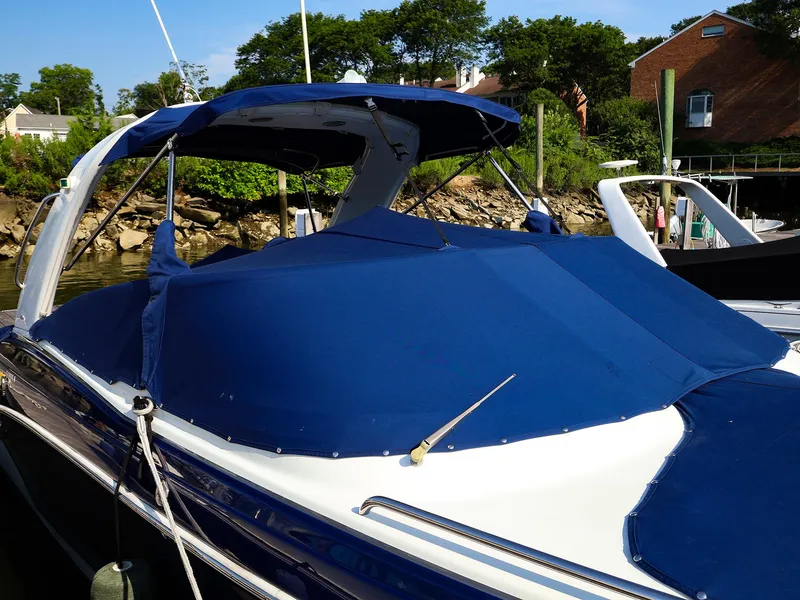 Slide: The Image of 2013 Formula 290 Bowrider with blue cover docked by lush greenery. - 4