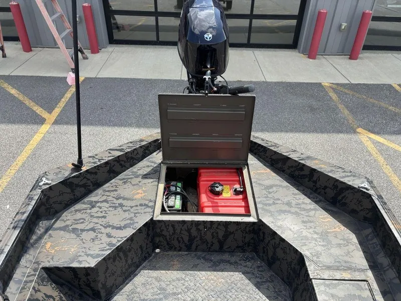 Slide: The Image of 2024 Edge Duck Boats 1756 DIAMONDBACK with open storage compartment and motor, parked outdoors. - 21