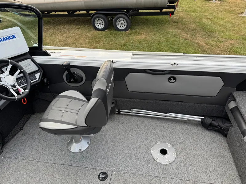 Slide: The Image of 2021 Lund 1875 Tyee boat interior with steering wheel and seat on trailer. - 17