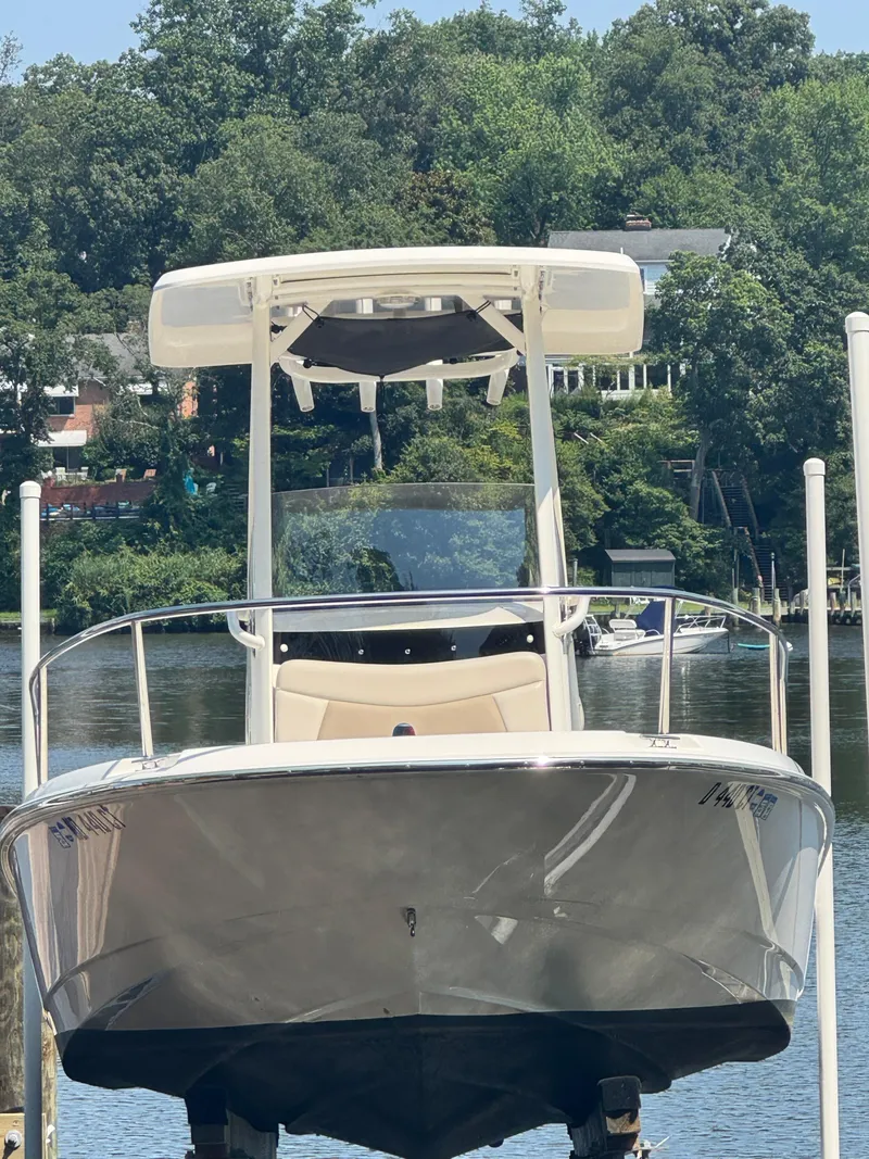 Slide: The Image of 2018 Boston Whaler 210 Dauntless boat docked on a serene lake with lush greenery. - 3