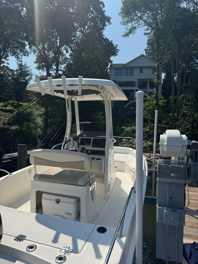 Slide: The Image of 2018 Boston Whaler 210 Dauntless boat docked near a lakeside house. - 6