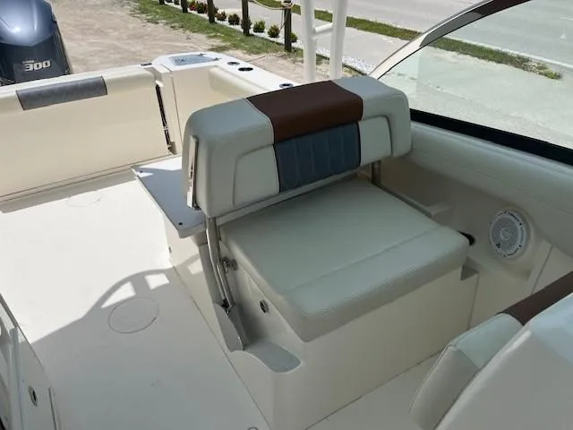 Slide: The Image of 2019 Cobia 240 Dual Console boat interior with cushioned seating and speaker. - 5