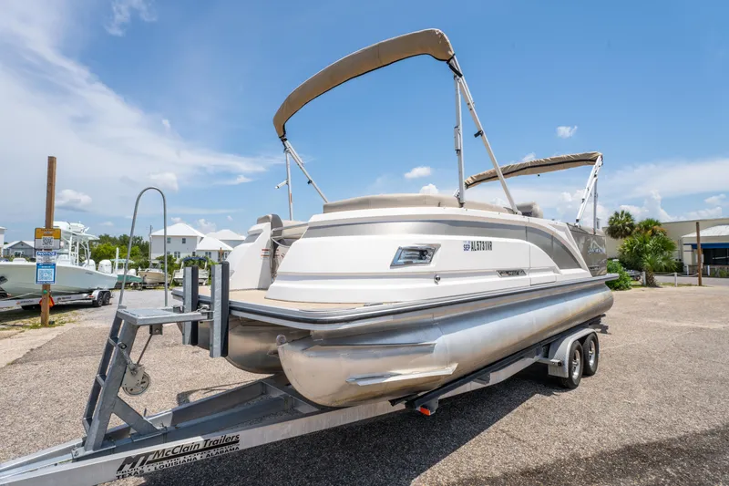 Slide: The Image of 2022 Silver Wave 2410 SW5 CLS pontoon boat on trailer under clear sky. - 2