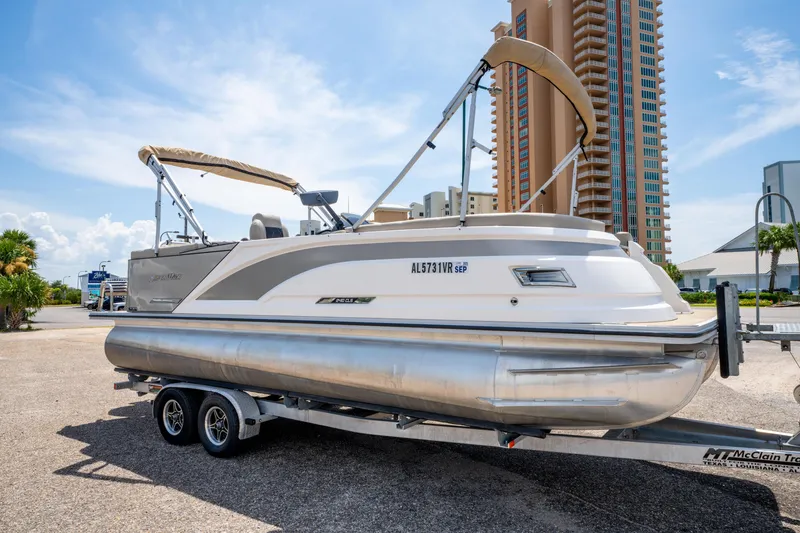 Slide: The Image of 2022 Silver Wave 2410 SW5 CLS pontoon boat on trailer, urban background, sunny day. - 3