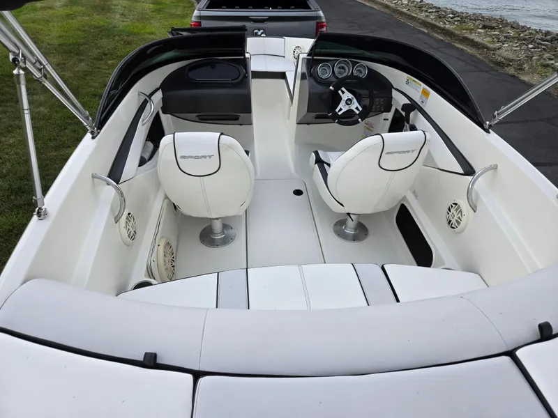 Slide: The Image of 2012 Sea Ray 190 Sport boat interior with white seating and steering wheel. - 10