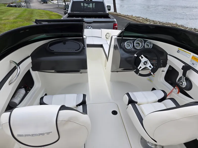 Slide: The Image of Interior of a 2012 Sea Ray 190 Sport boat with white seating and steering wheel. - 11