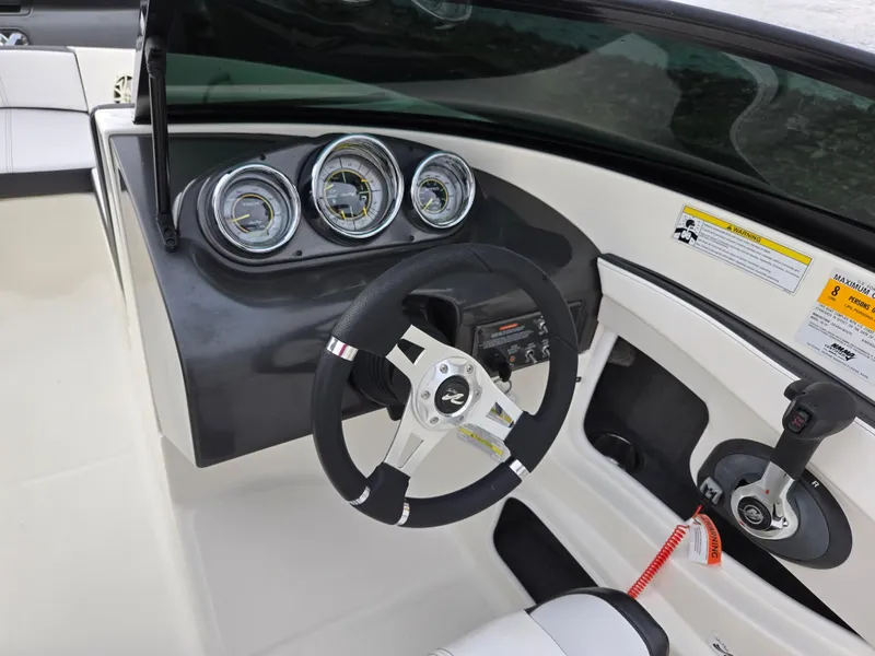 Slide: The Image of 2012 Sea Ray 190 Sport boat dashboard with steering wheel and gauges. - 13