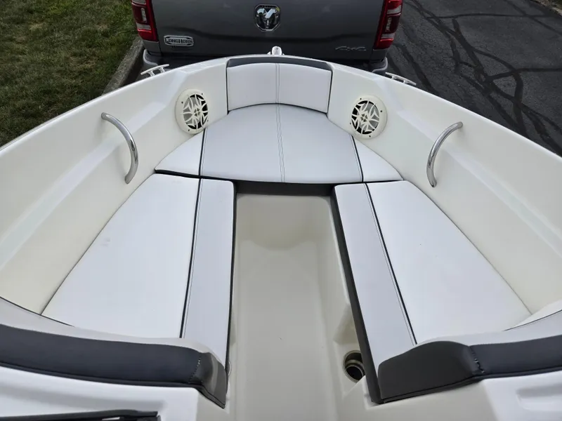 Slide: The Image of 2012 Sea Ray 190 Sport boat interior with white cushioned seating and speakers. - 17