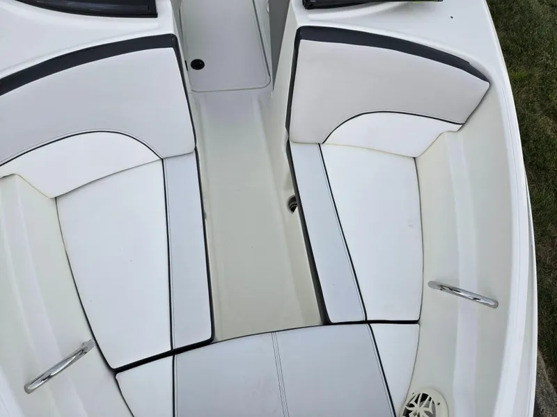 Slide: The Image of Interior seating of a 2012 Sea Ray 190 Sport boat, featuring white and black upholstery. - 18