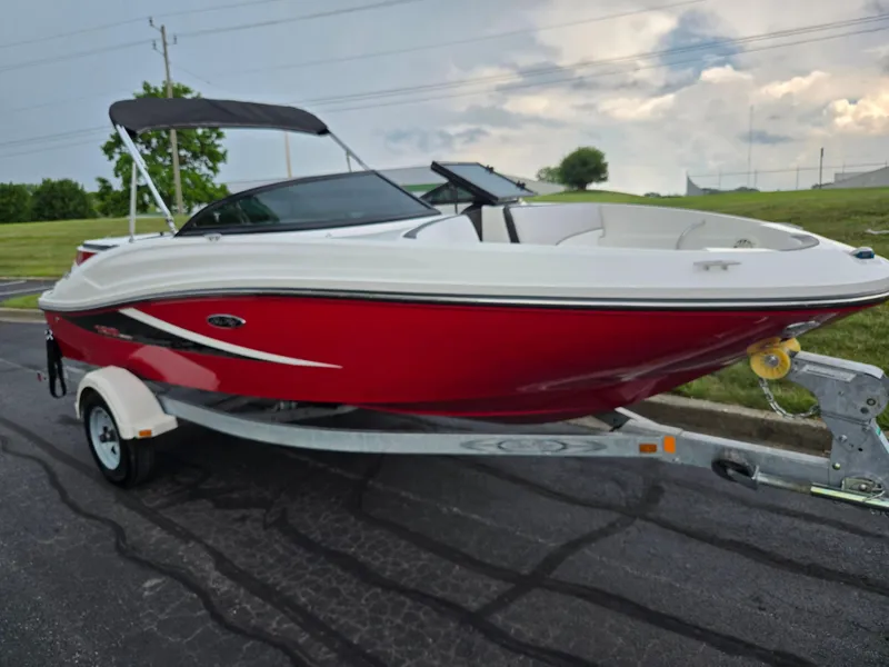 Slide: The Image of 2012 Sea Ray 190 Sport boat on trailer, red and white design, parked outdoors. - 5