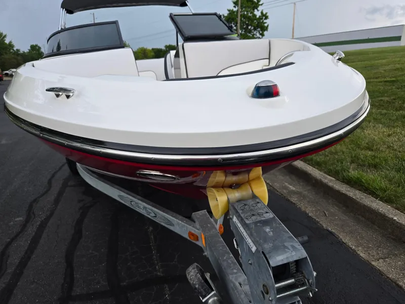 Slide: The Image of 2012 Sea Ray 190 Sport boat on trailer, parked on asphalt near grass. - 6
