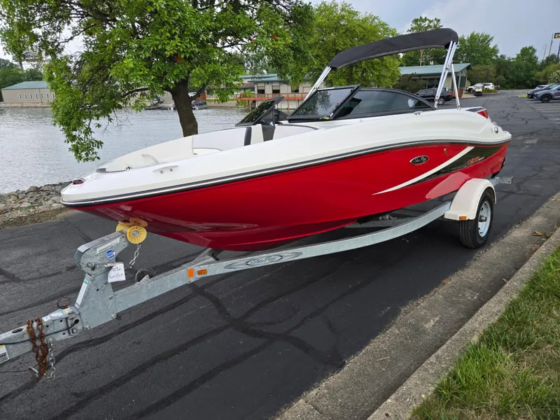 Slide: The Image of 2012 Sea Ray 190 Sport boat on trailer, parked near a waterfront. - 8