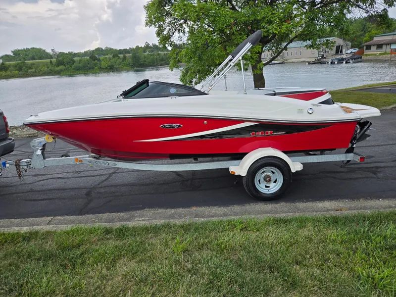 Slide: The Image of Red 2012 Sea Ray 190 Sport boat on trailer by a lakeside road. - 9