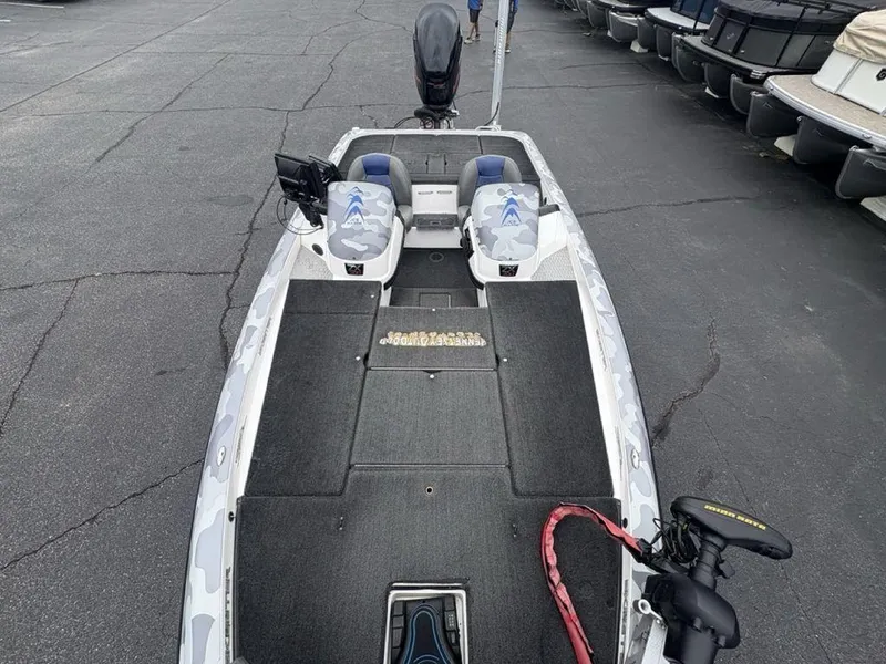 Slide: The Image of 2008 Skeeter ZX200 boat with camo seats and trolling motor, parked in a marina. - 20