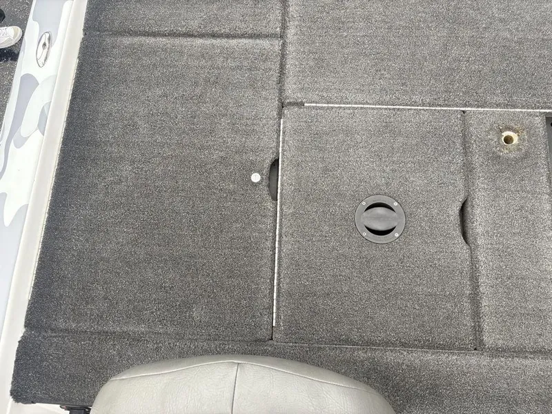 Slide: The Image of 2008 Skeeter ZX200 boat deck with gray carpet and storage compartment. - 26