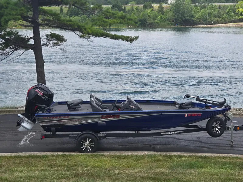 The Image of 2021 Lowe Stinger 188 boat on trailer by a scenic lake. - 0