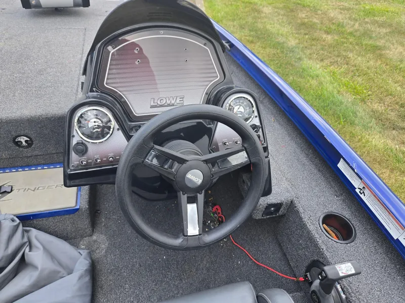 Slide: The Image of 2021 Lowe Stinger 188 boat dashboard with steering wheel and gauges. - 12